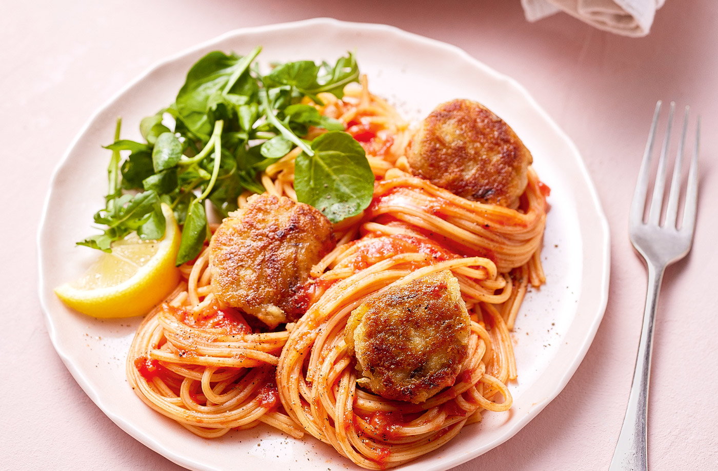 spaghetti and mackerel balls served up on a plate